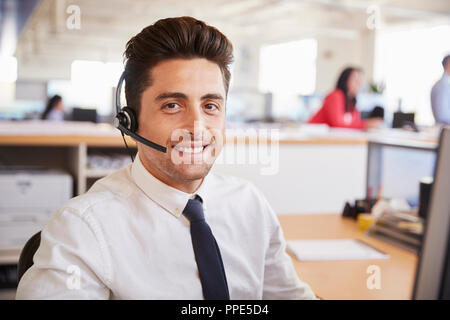 Hispanic male call centre worker smiling to camera, close-up Stock Photo