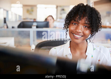Young black woman working in a call centre smiling to camera Stock Photo