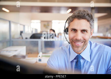 White male call centre worker smiling to camera Stock Photo