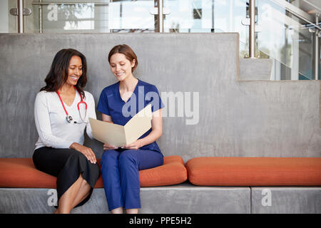 Two female healthcare workers looking at a file together Stock Photo