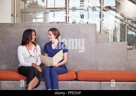 Two female healthcare workers discussing a medical record Stock Photo