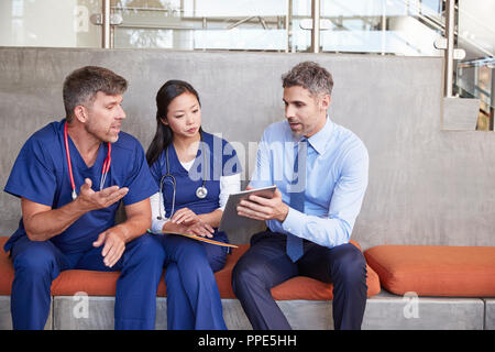 Healthcare workers in discussion using a tablet computer Stock Photo