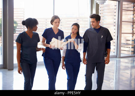 Healthcare colleagues discussing notes in hospital corridor Stock Photo