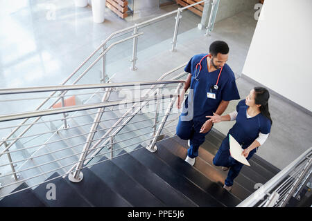 Two healthcare colleagues talking on the stairs at hospital Stock Photo