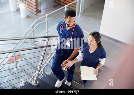 Two healthcare colleagues talking on the stairs at hospital Stock Photo