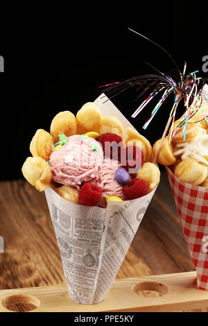 Egg waffle with ice cream and fruits with syrup Stock Photo - Alamy