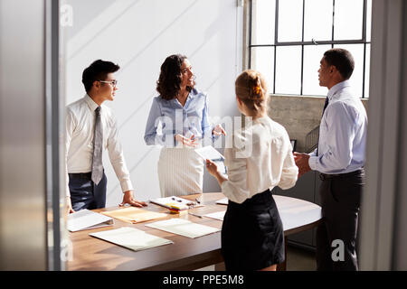 Four business colleagues working together in a small office Stock Photo