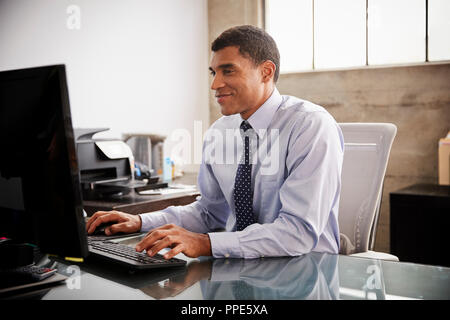 Mixed race businessman using computer in an office Stock Photo