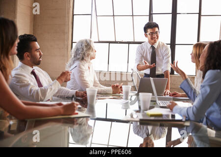 Asian businessman addressing colleagues in meeting, close up Stock Photo