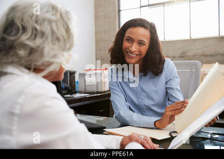 Smiling female analyst in consultation with senior woman Stock Photo