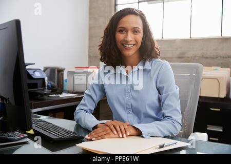 Young female professional sitting at desk in an office Stock Photo