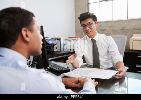 Young Asian professional in meeting with mixed race man Stock Photo