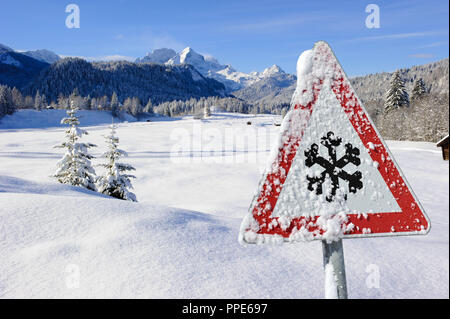 Warning sign on a road against ice, snow and icy conditions Stock Photo
