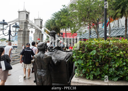 F1 Supporters Walking Past The River Merchants Bronze Sculpture near The Maybank Building and Cavanagh Bridge in Downtown Singapore Asia Stock Photo