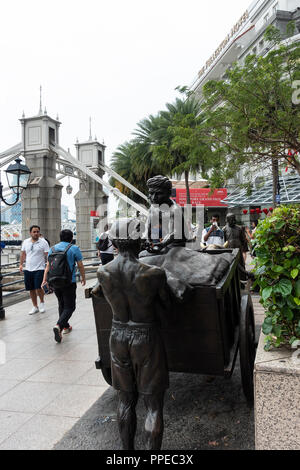 F1 Supporters Walking Past The River Merchants Bronze Sculpture near The Maybank Building and Cavanagh Bridge in Downtown Singapore Asia Stock Photo