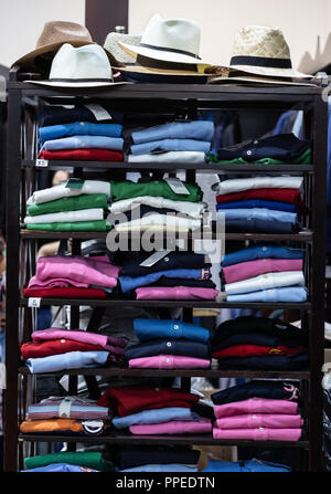 shelving furniture with shirts and shirts folded in different heights and colors Stock Photo
