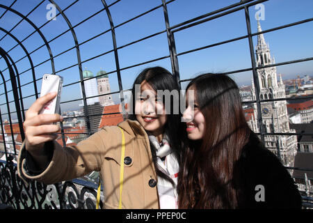 Two tourists from China take photographs on the viewing platform on the tower of the Old Peter. Stock Photo