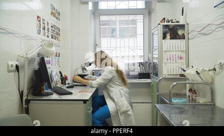 Doctor woman working with a microscope in Laboratory. Female scientist looking through a microscope in lab. Scientist using a microscope in a laboratory. Stock Photo