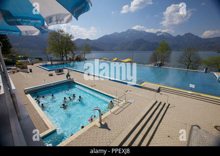 The Kochelsee and the 'Trimini' indoor and outdoor pools in the foreground and mountains in the background. Stock Photo