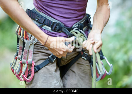 Anonymous woman rock climber with gear attached to her waist Stock Photo