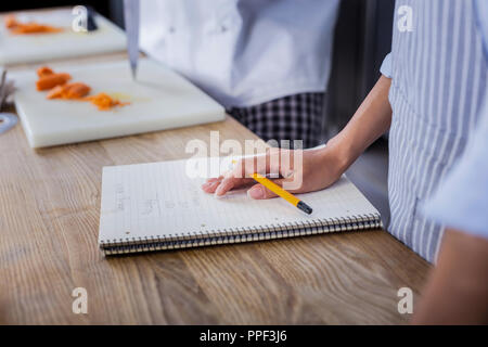 Young lady making important notes in the notebook Stock Photo