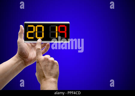 Two hands holding a mobile Smartphone and new year 2019 coutdown Stock Photo