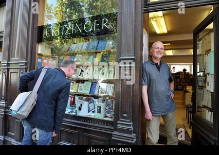 New and old in the university district of Munich. The owner of the Kitzinger antiquarian bookshop, Bernhard Kitzinger, at the entrance door to his shop. Stock Photo