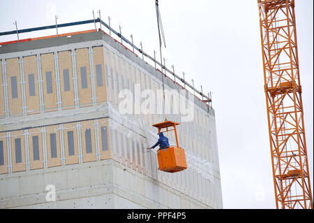 Construction work at the newly planned NS Dokumentationszentrum (Documentation Centre for the History of National Socialism) in the Brienner Strasse. A construction worker is working from a cabin, which is attached to the winch of a crane. Stock Photo
