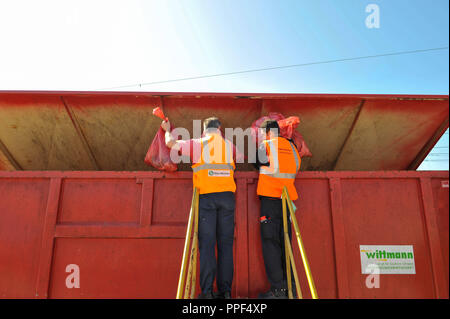 The cleaning personnel of Deutsche Bahn doing the daily cleaning of S-Bahn trains. The picture shows the disposal of garbage bags full of trash. Stock Photo