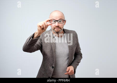 Funny middle aged man looking through glasses. His eyes are big. Stock Photo