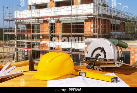 Helmet, tools and circular saw with a shell in the background | usage worldwide Stock Photo