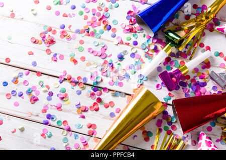 Party background. Party caps and confetti on white wooden background. Copyspace Stock Photo