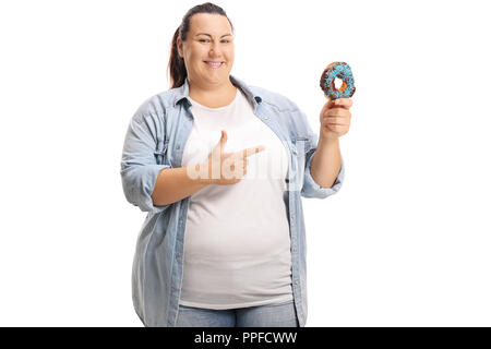 Overweight woman holding a donut and pointing isolated on white background Stock Photo