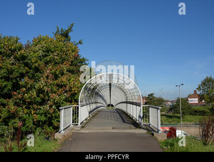 Enclosed pedestrian footbridge with steel safety cage, over m60 motorway at junction 17, whitefield interchange in greater manchester uk Stock Photo