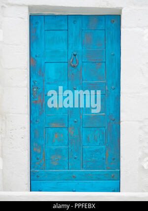 Old blue door on white stone wall Stock Photo