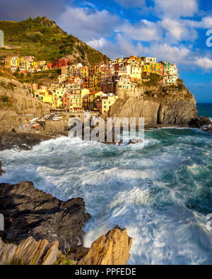 Swirling ocean at the foot of medieval town of Manarola in The Cinque Terre, Liguria Italy Stock Photo