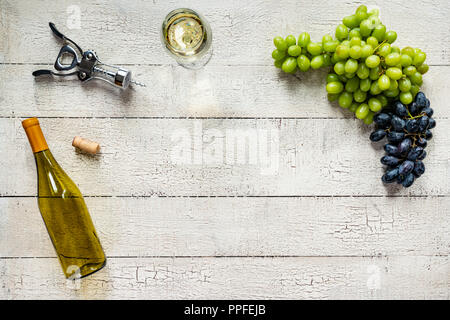 White wine with grapes on a weathered, peeling white wood table Stock Photo