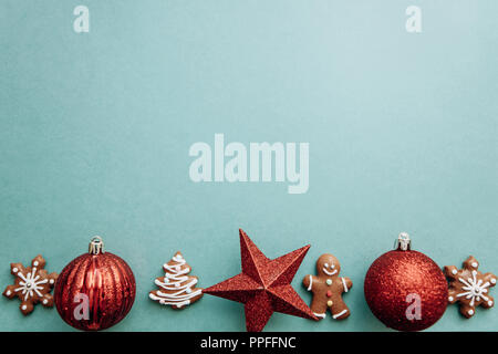 Christmas concept. Christmas balls and gingerbread cookies on a green background. Stock Photo
