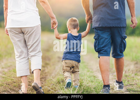 Happy grandparents on a walk outside with their grandchild Stock Photo