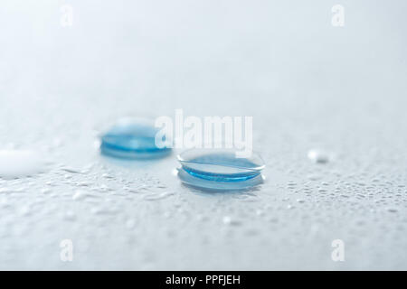 close up view of contact lenses on white background with water drops Stock Photo