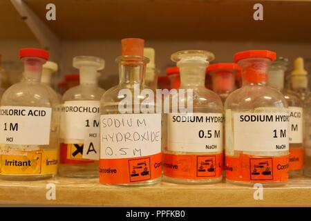 Various bottles of chemicals including Sodium hydroxide in a school chemistry lab Stock Photo