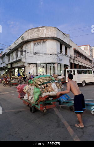 Cebu, Philippines-October 18, 2016: Porter transports sacks and baskets on a flatbed trolley-Carbon Market oldest and largest farmer's market in town- Stock Photo