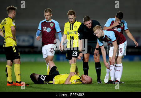 Burton Albion's Liam Boyce lies injured on the pitch during the third round Carabao Cup match at the Pirelli Stadium, Burton. Stock Photo