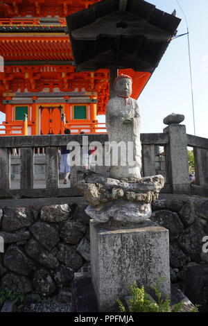 Kyoto, Japan - August 01, 2018: Jizo Buddhist figure with the three storied pagoda in the background at the Kiyomizu-dera buddhist temple, a UNESCO Wo