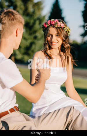 beautiful wedding couple clinking with wine glasses on picnic Stock Photo