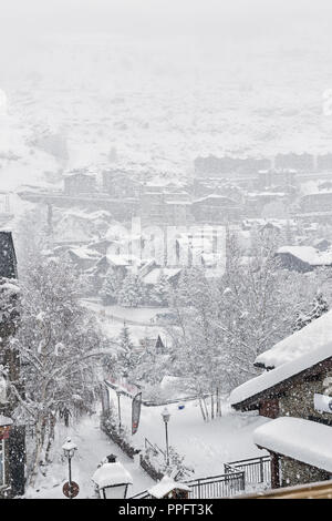 Cars on the parking in snow. Cloudy winter day, snowfall, snowdrifts on roofs of cars. Near traces from tires on snow Stock Photo