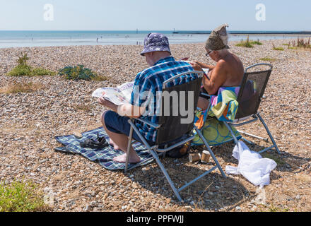 Couple of people sitting on beach chairs in Summer in Littlehampton, West Sussex, England, UK. Stock Photo