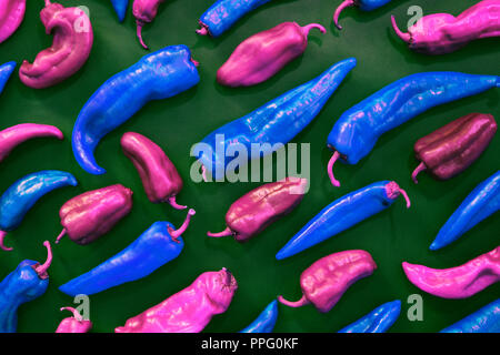 blue and pink peppers shapes creative pattern on a green background. Vegetables and food figures abstract colorful background. Top view. Pop art style Stock Photo