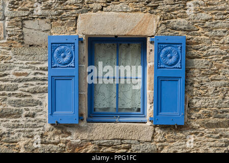 Decorative blue wooden shuttered window on old house Brittany France Stock Photo