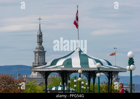 A decorative gazebo on the Dufferin Terrace. The ornamental steeple of the Camille-Roy Building (Séminaire de Québec) can be seen in the background. Stock Photo